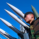 A North Korean soldier stands guard over missiles so advanced, Iraq is prohibited from possessing them.